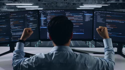 Rückansicht des Happy Asian Man-Entwicklers, der beim Schreiben von Code im Rechenzentrum feiert