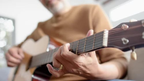 Senior Man Plays Acoustic Guitar Indoors
