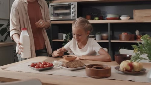 Girl Eating Breakfast Cereal at Kitchen Table