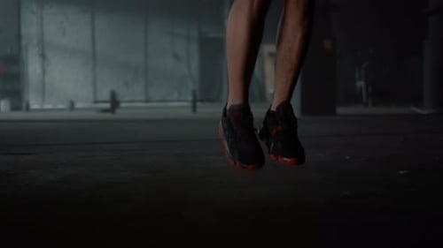 Unrecognizable Athlete Legs Jumping on Skipping Rope in Gym. Closeup African American