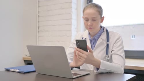 Young Female Doctor Using Smartphone in Hospital