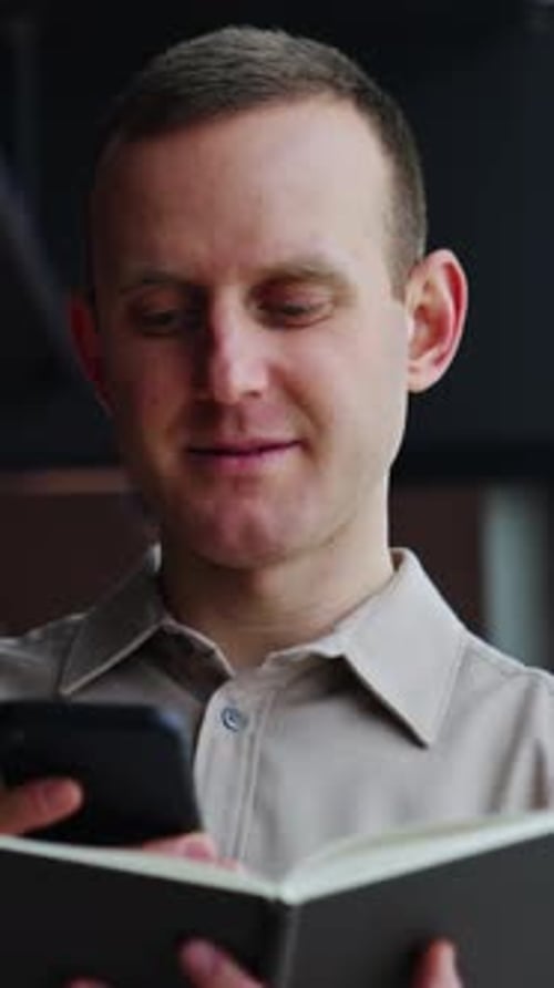 Young Adult Man with Phone and Book