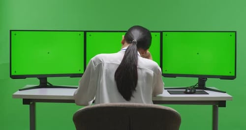 Woman Having Headache While Working With Mock Up Multiple Computer Monitor In Green Screen Studio