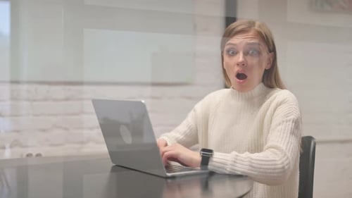 Shocked Woman Working on Laptop in Office