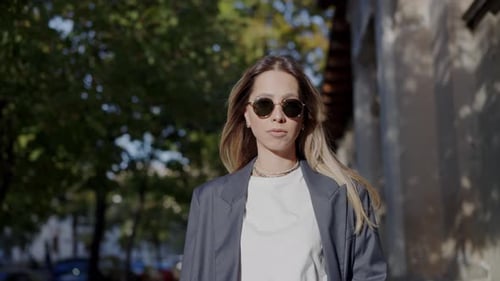Stylish Young Woman Walking on a Sunny City Street