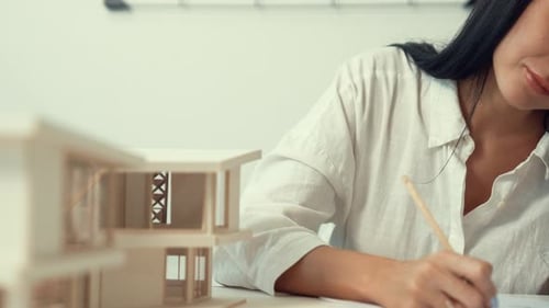 Architect using ruler to measure house model at modern office. Immaculate.