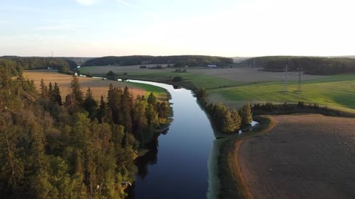 Kleiner Fluss auf dem Land während des Sonnenuntergangs. Drohnenschuss