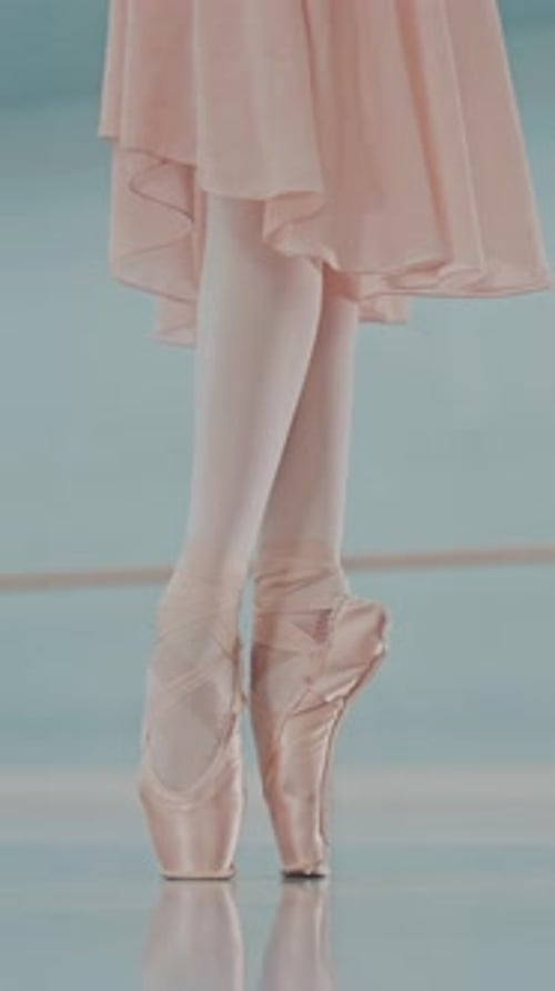 Ballerina's feet in ballet shoes. Close up of ballet dancer's legs in pointe. Vertical/