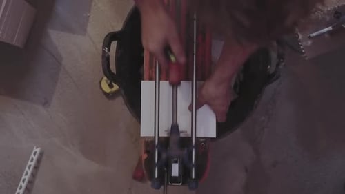 Person Cutting Tile With Tile Cutting Machine
