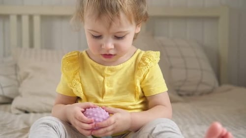 Cute Child Plays with Tactile Toy at Home