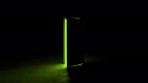 Mysterious green light shining through opening door in dark room
