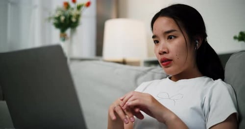 Woman Celebrates Success with Laptop at Home