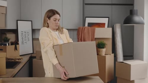 Middle Aged Woman Carrying Heavy Cardboard Boxes in New Modern Room Moving to Nice Apartment and