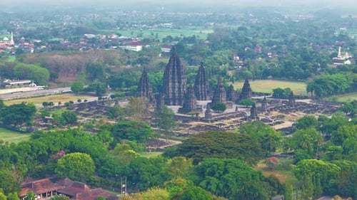 Aerial view of Prambanan Temple surrounded by green trees. All temple complex visible on the video.