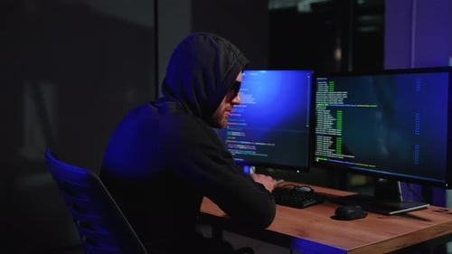 Hooded Figure Typing Code at a Computer