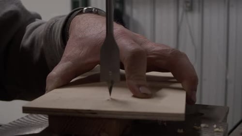 Adult drilling into wood close up shot