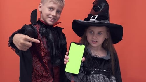 Children in Costumes Hold Up Green Screen Phone