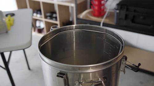 Inserindo uma tela de metal de fundo falso e a cuba de mistura em uma chaleira de metal, ângulo alto, close-up