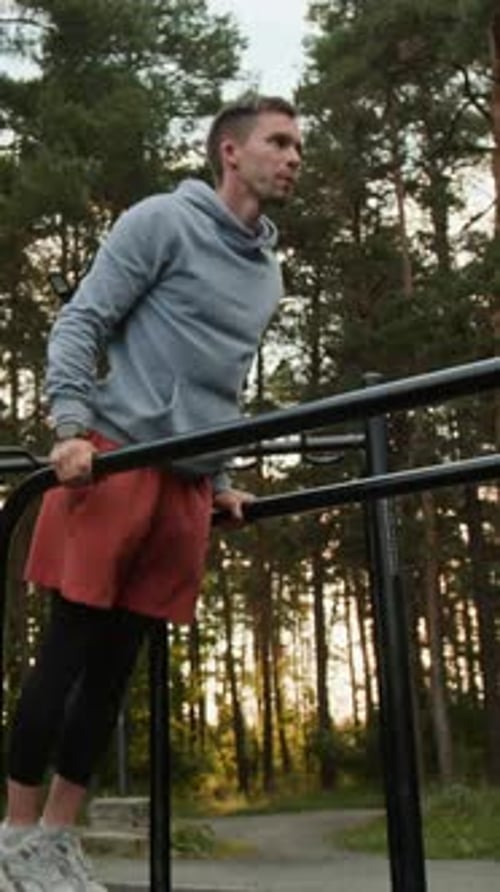 Man Exercising on Parallel Bars in Outdoor Park