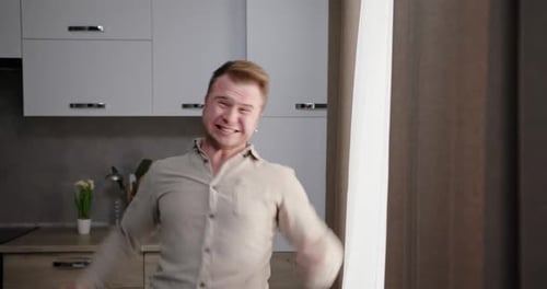 Man Yelling and Raising His Arms Indoors