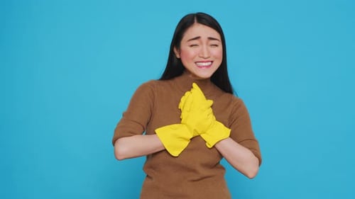 Woman Smiles Wearing Yellow Cleaning Gloves in Studio
