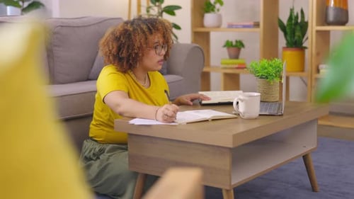 Laptop, notebook and woman writing in the living room studying for a college exam