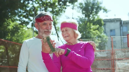 Active Senior Couple Looking at Phone Together Outdoors
