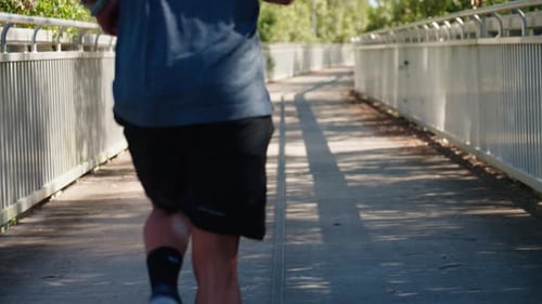 Close Up First Person View Of Athlete Legs And Body As Man Runs Across Bridge, 4K Slow Motion