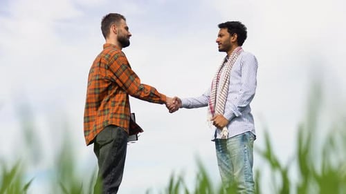 Two Multiethnic Farmers Talk on the Field Then Shake Hands Agrarian Partnership
