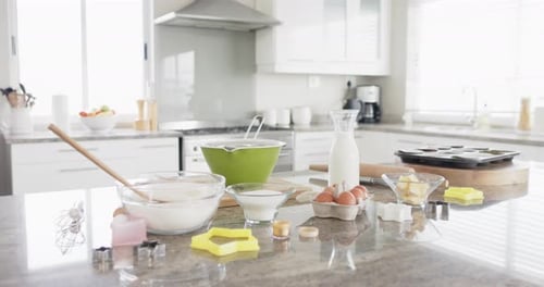 General view of kitchen with baking ingredients and equipment on countertop, slow motion