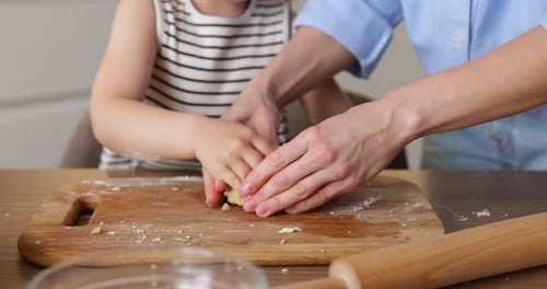 Mother and Child Toddler Kneading Dough Together in Kitchen