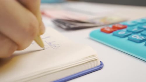 Close-up of person making economic, financial calculations.