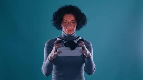 Woman Holds and Puts on VR Headset