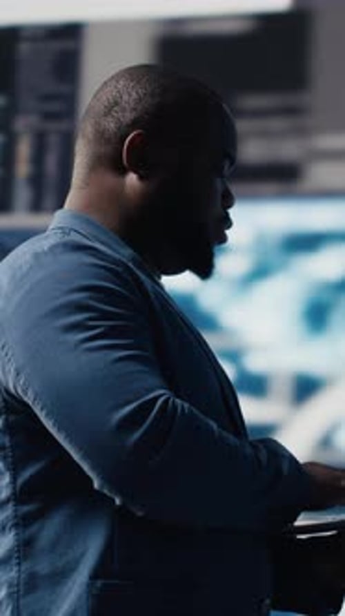 Vídeo vertical: Ingeniero de TI negro que trabaja en un entorno digital con lenguaje de programación