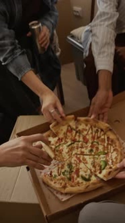 Vertical de amigos que comparten una pausa para comer pizza durante la mudanza