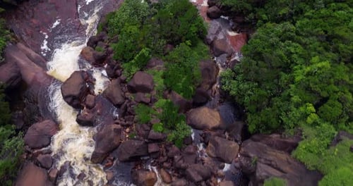 Aerial View of a Tropical Waterfall Flowing Through Lush Jungle