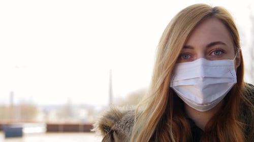 Woman wearing a mask looking at the camera