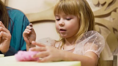 Girl Creating Colorful Crafts with Hands in a Playful Environment