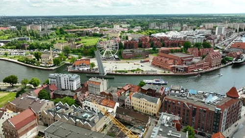 Aerial view of Gdańsk, showcasing the city's historic buildings, modern Ferris wheel, and the scenic