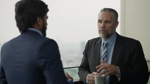 Businessmen Talk During Meeting in Office Setting
