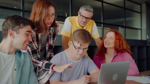 Team Collaborating Around Laptop in Modern Office