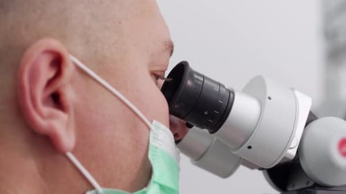 Man in Mask Using a Microscope