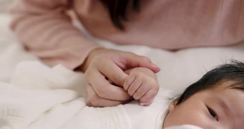 Parent Tenderly Holds Newborn Baby's Hand