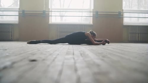 Young Woman Stretching Splits and Bending in Studio