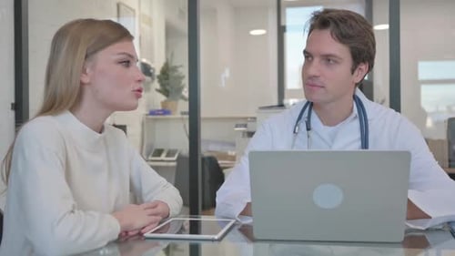 Doctor Talking with Young Woman in Clinic