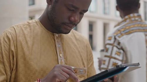 African American Man Using Digital Tablet in Street