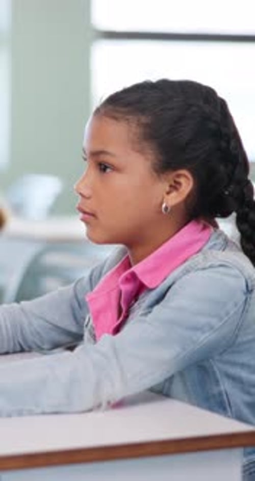 Attention, education and girl child at desk in classroom for development, future or growth