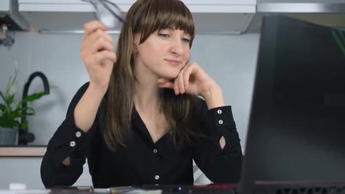 Confident Businesswoman Looking at Screen at Laptop and Spinning Eyeglasses in Hand While Working at