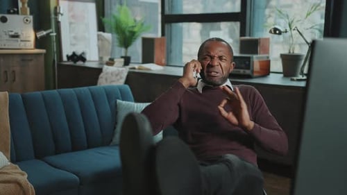 Man Talking on Phone with Upset Expression Indoors