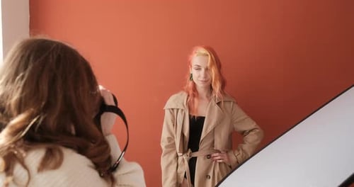 Red Haired Model at a Photo Shoot in the Studio Female Photographer with Assistant in the Process of